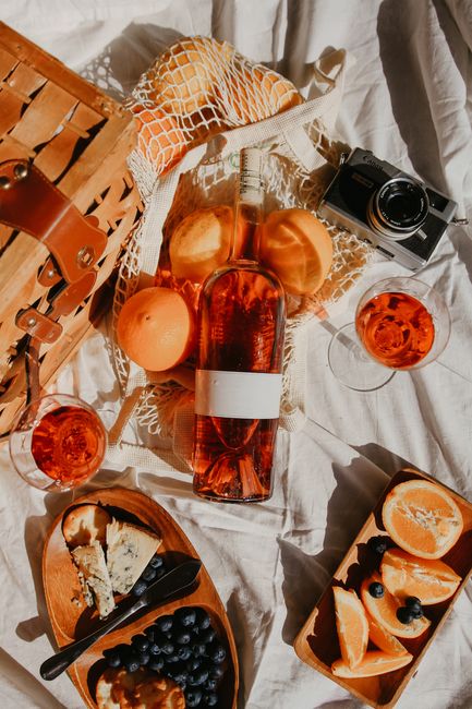 A top view of a stylish picnic setup in Napa with wine, fruits, and cheese.