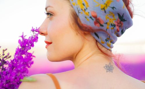 Free A woman in a floral headscarf enjoying lavender in a sunny field, creating a serene and colorful atmosphere. Stock Photo