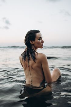 A woman enjoying a serene moment at the beach during sunset.