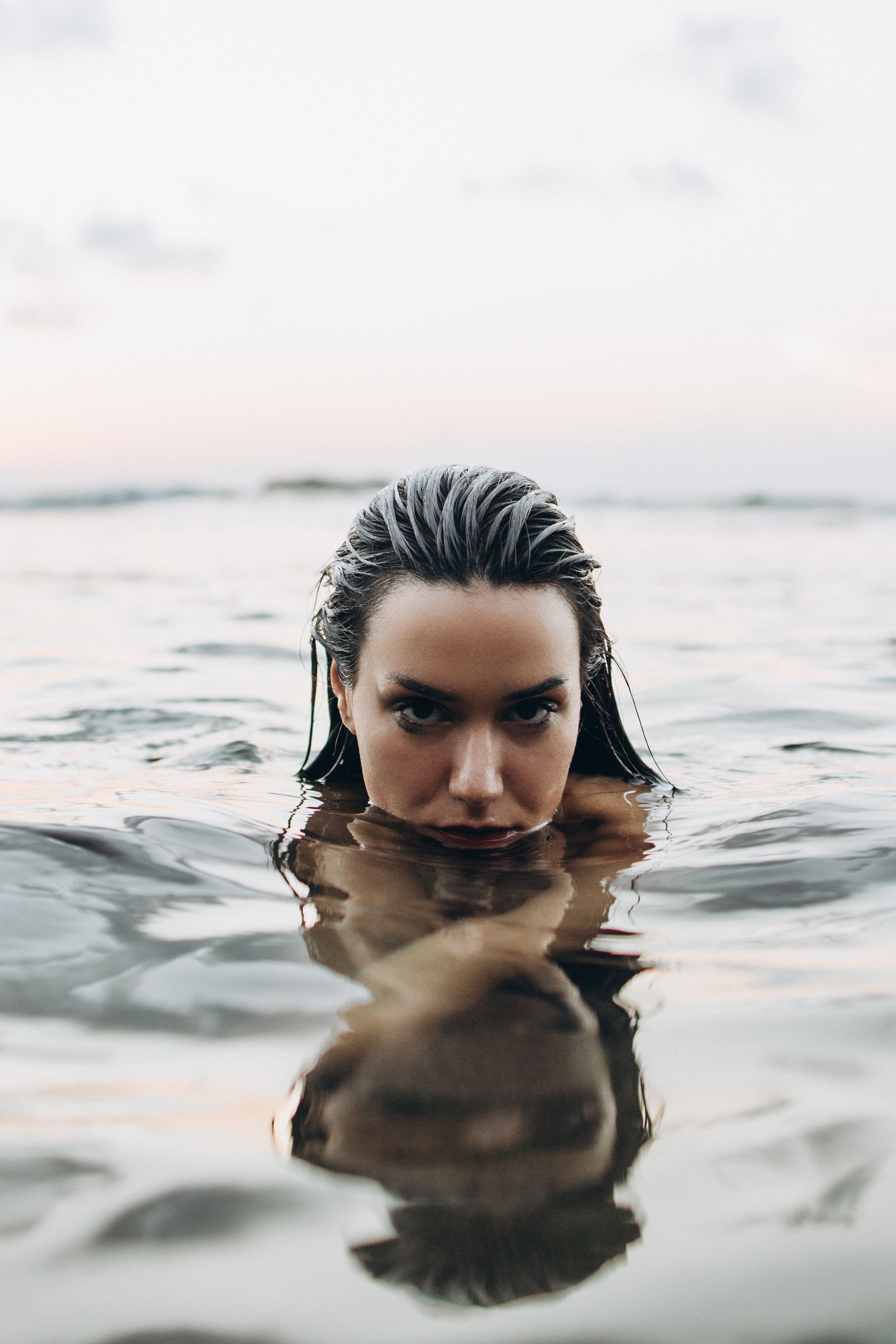 A woman in the water with her hair in the water · Free Stock Photo