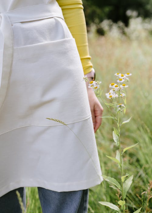 Close-up of Woman Wearing an Apron Standing on a Meadow 