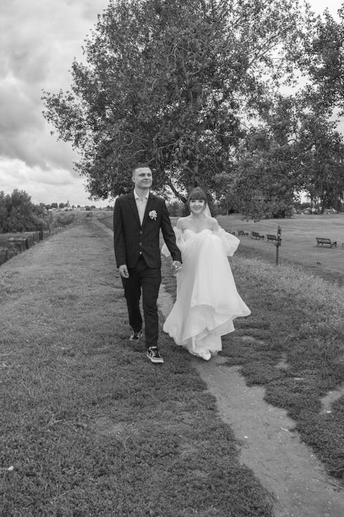 Foto profissional grátis de andando, fotografia de casamento, mãos dadas