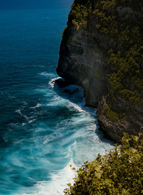 Free Majestic cliffs meet turquoise ocean waves in Indonesia, showcasing nature's beauty and power. Stock Photo
