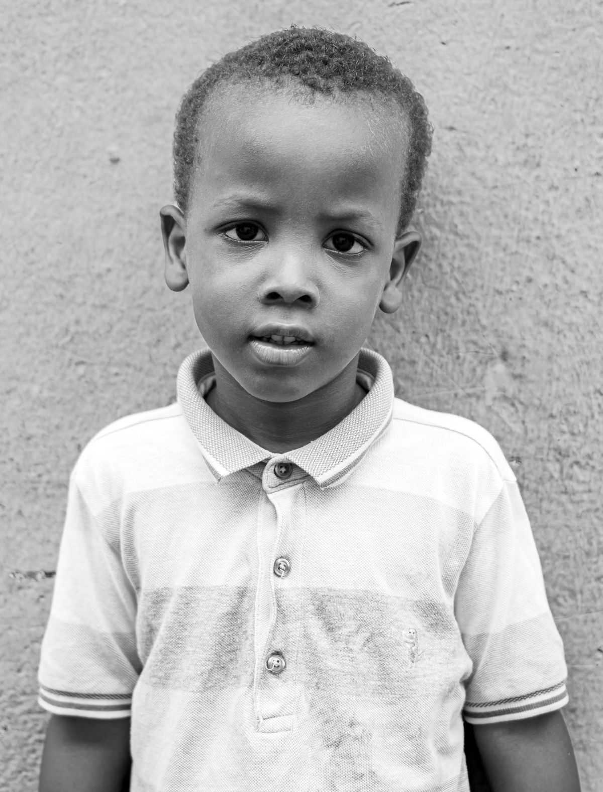 Black and White Portrait of a Thin Boy in Ragged Clothes Standing by a ...