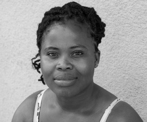 Free Close-up black and white portrait of a woman with natural hair and a warm smile. Stock Photo