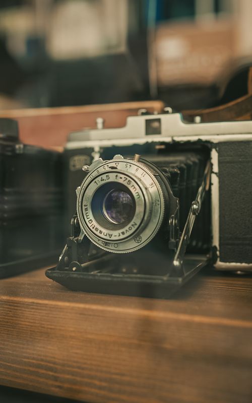 Free Close-up of a vintage analog camera lens in a retro shop setting. Stock Photo