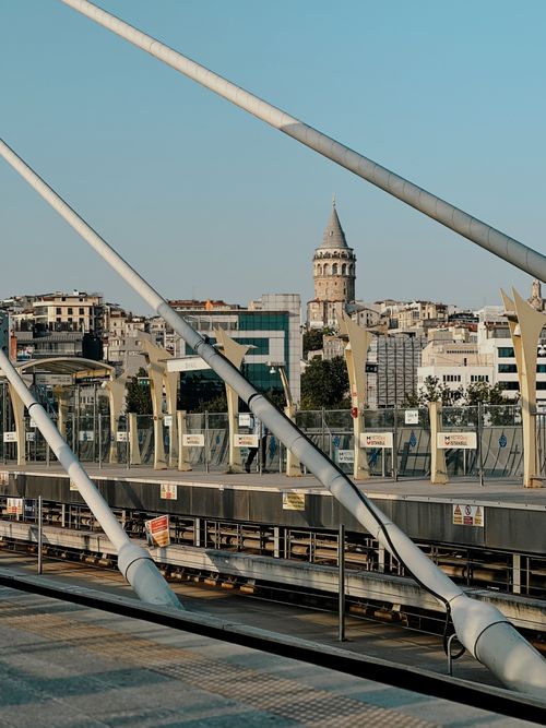 Free View of the iconic Galata Tower through the structure of Halic Bridge in Istanbul, Turkey. Stock Photo