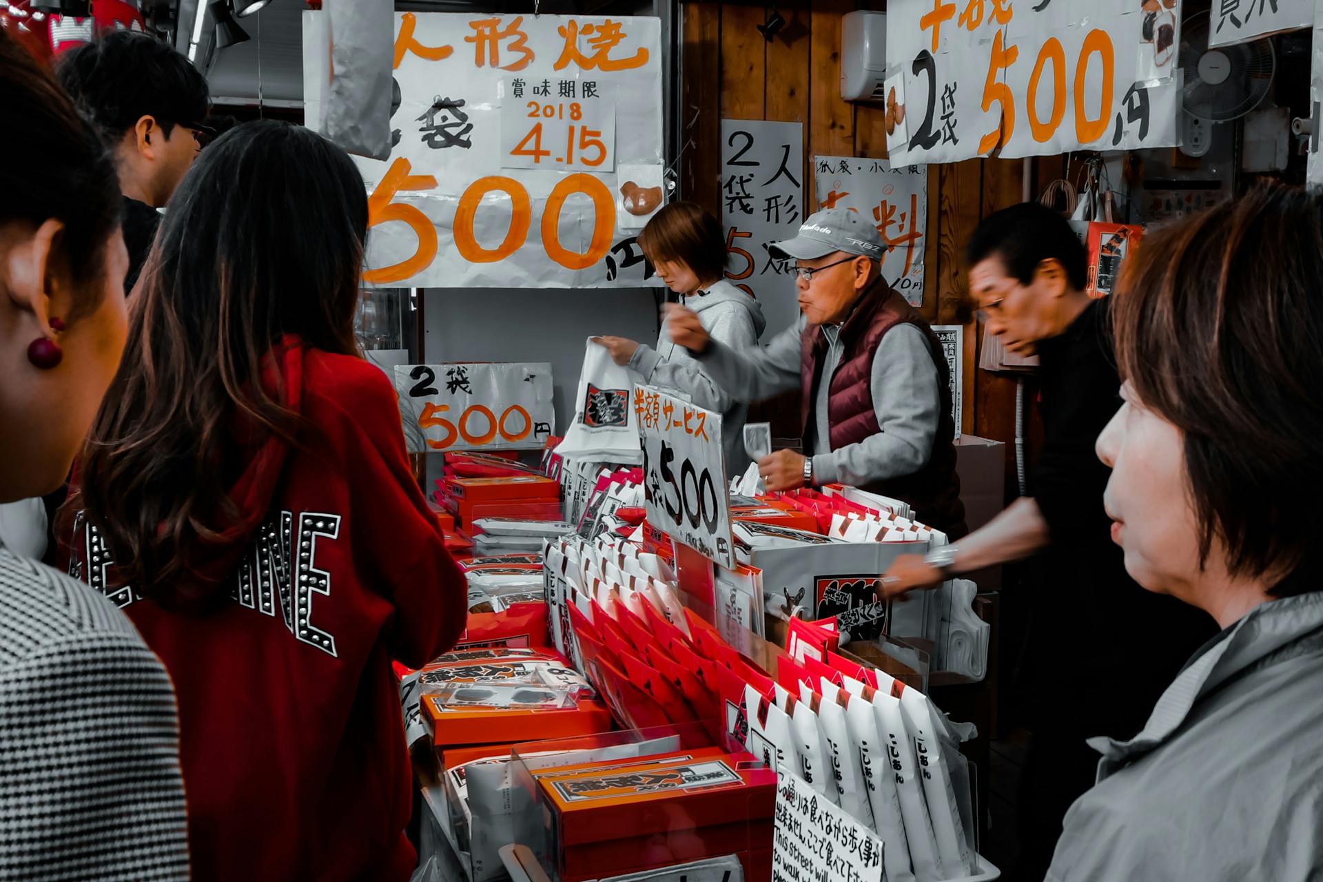 Busy street market with people buying and selling goods, vibrant atmosphere.