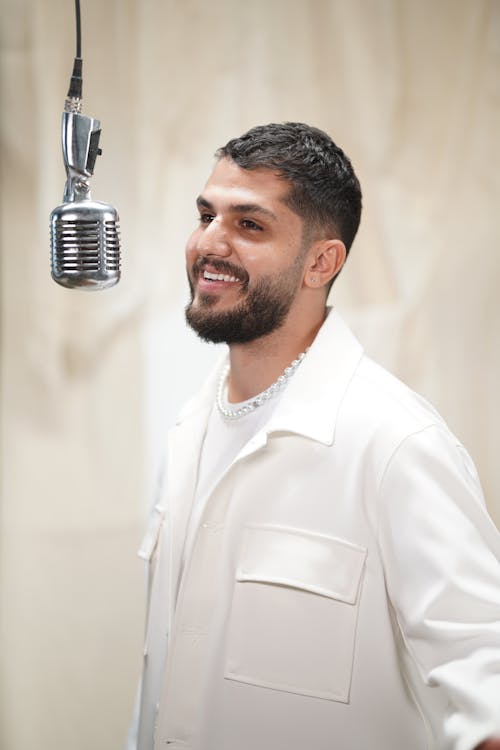 Smiling Man in Shirt Standing by Microphone