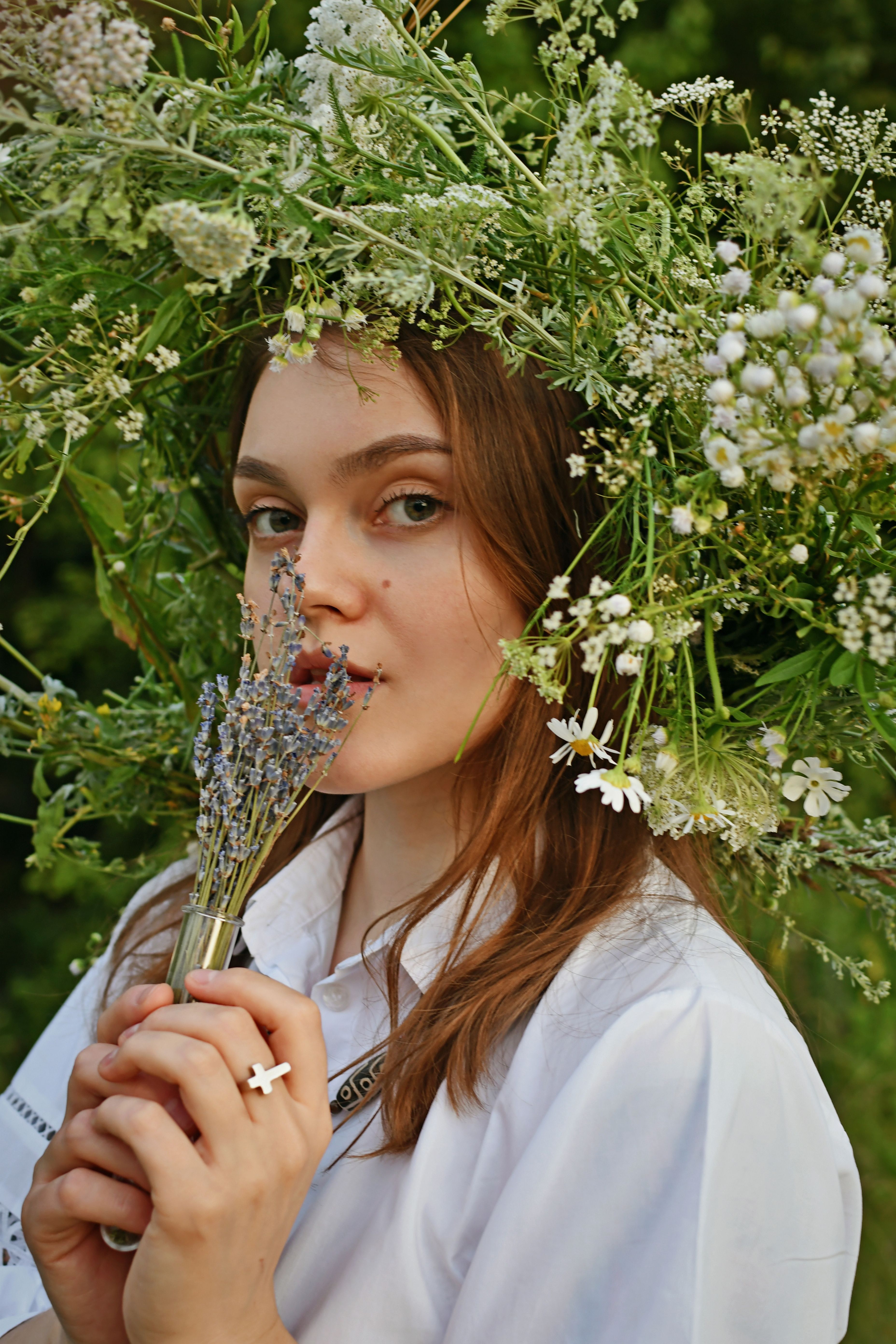 Portrait of a woman with a delicate floral wreath and lavender bouquet.