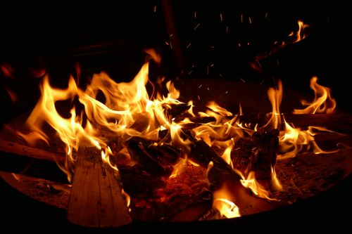 Free A bright and warm campfire burning with flames and sparks at night, outdoors. Stock Photo