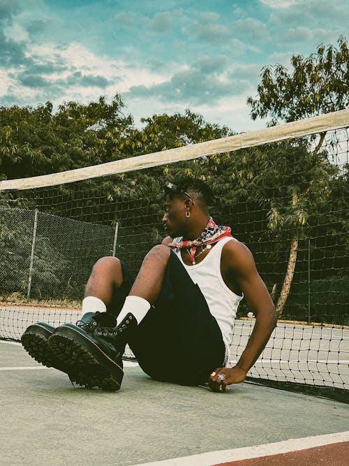 Man Sitting on Tennis Court