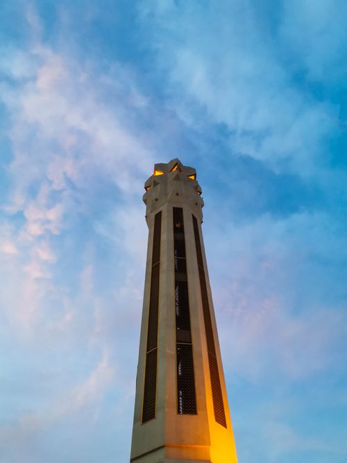 Free A tall tower beautifully illuminated against a vibrant blue sky, showcasing architectural elegance. Stock Photo