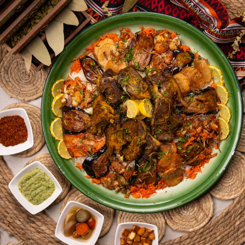Free Top view of a traditional Arabian feast with lamb, rice, and side dishes on a decorative tray. Stock Photo