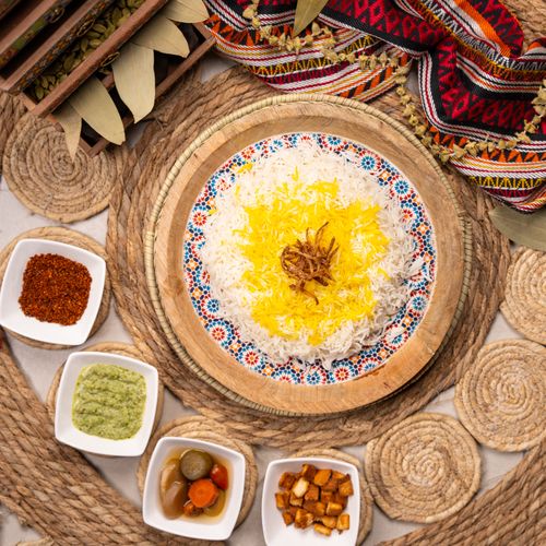 Free Top view of Persian rice with saffron and assorted condiments, creating a vibrant and cultural dining experience. Stock Photo