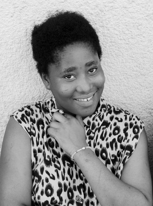 Free A cheerful woman with short hair smiling in a black and white portrait. Stock Photo