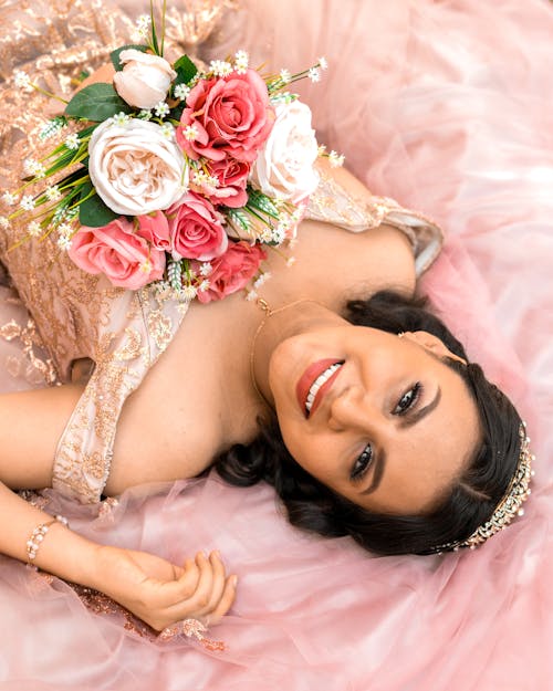 Free Smiling Woman in Dress Lying Down with Flowers Stock Photo