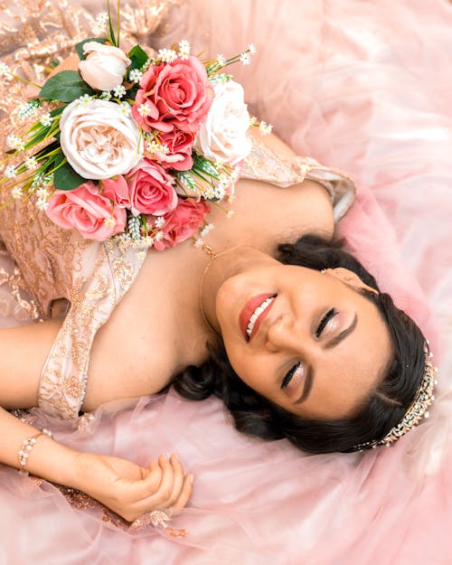 Free Smiling Brunette Woman Lying Down with Flowers Bouquet Stock Photo