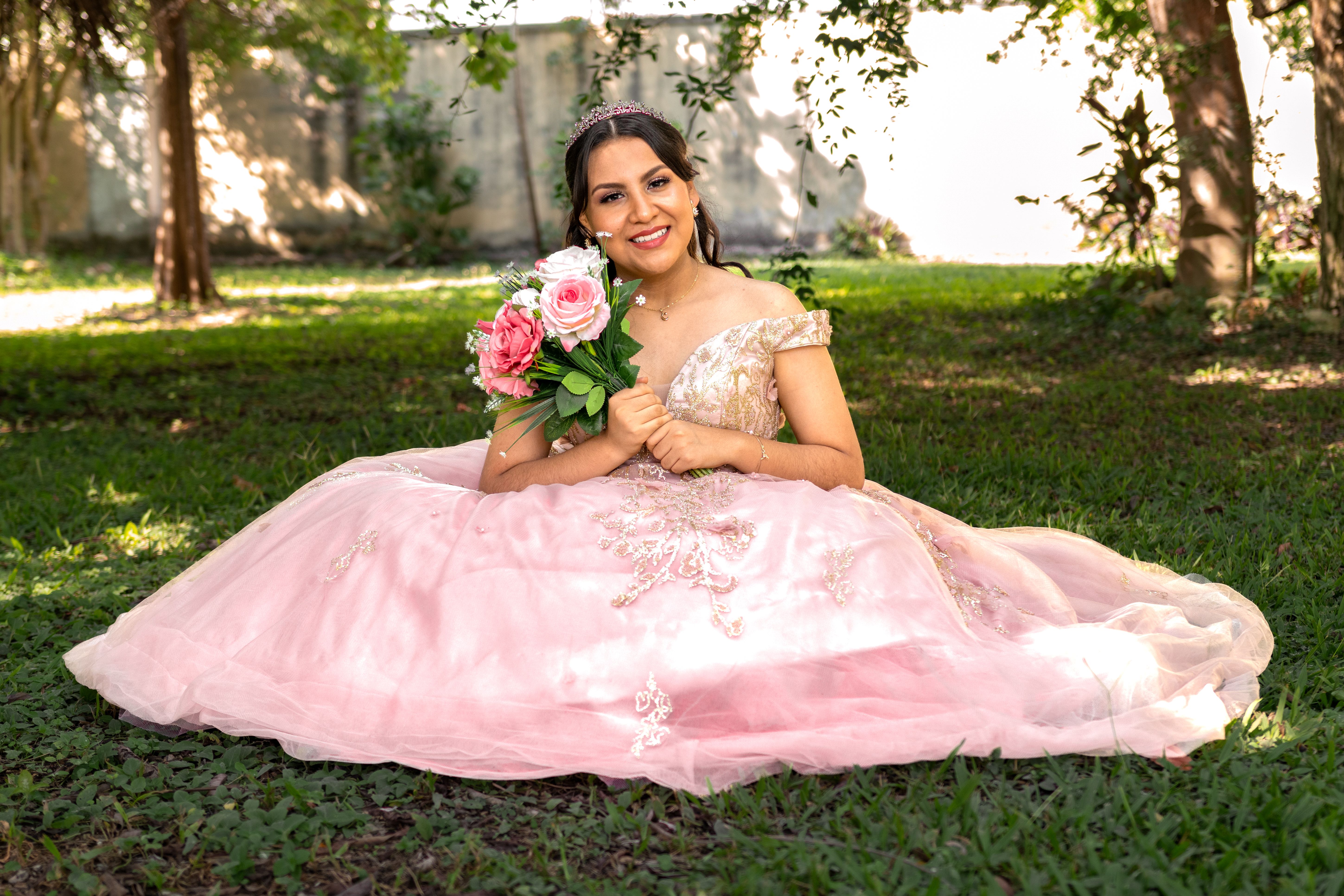 A Bride in a Pink Dress Sitting on Grass · Free Stock Photo