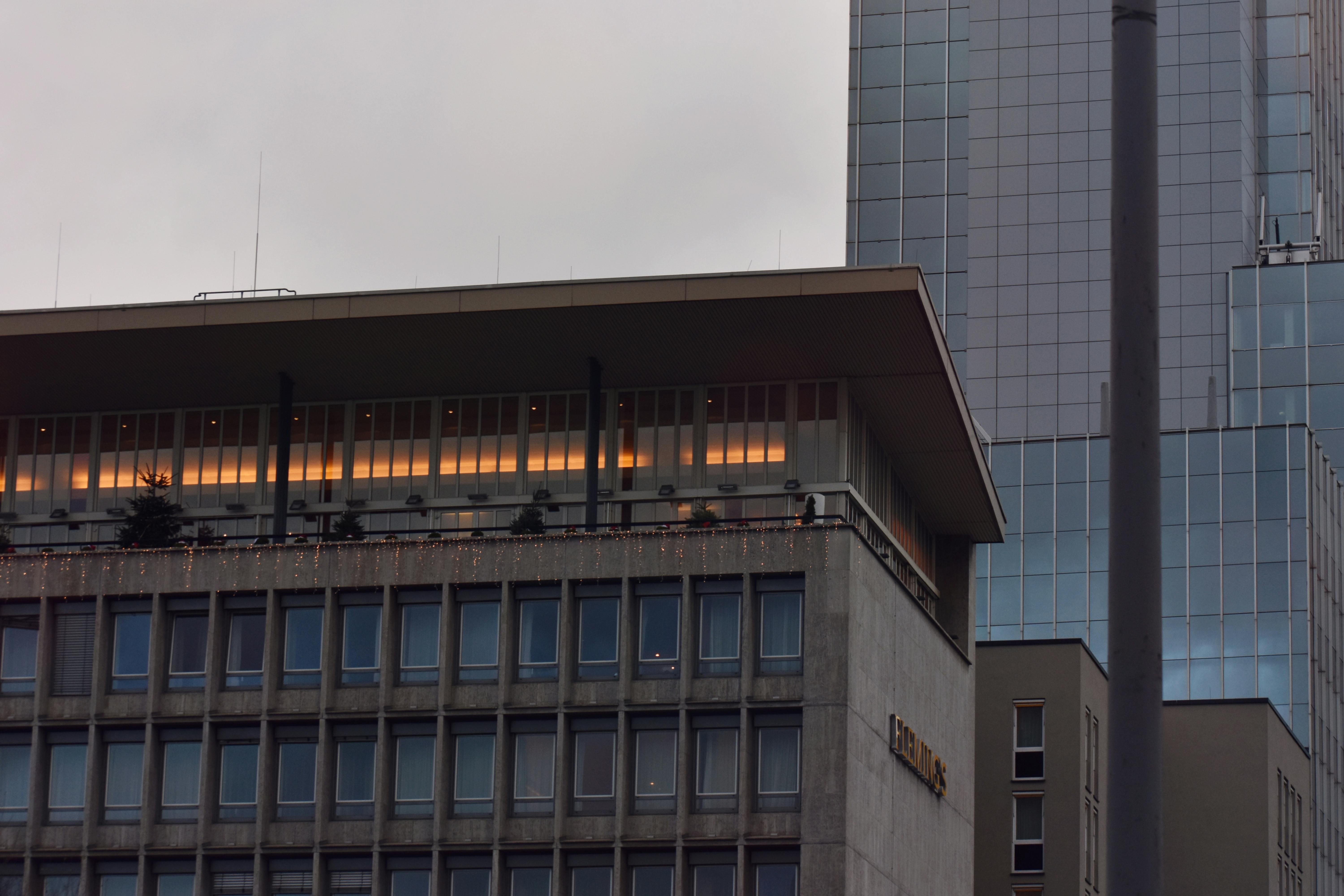 黄昏时分，一座现代摩天大楼在温暖灯光映照下，展现出城市的优雅