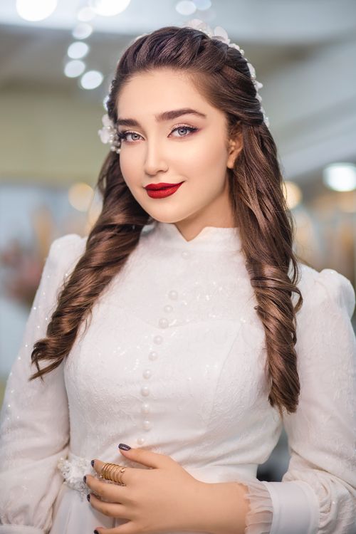 Free Portrait of an elegant woman in a white dress, showcasing red lips and stylish hairstyle. Stock Photo