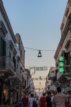 Explore the vibrant evening street life in Polignano a Mare featuring classic Italian architecture.