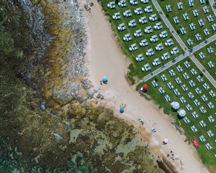 Explore the stunning aerial view of Torre Canne's beach with umbrellas and a neatly arranged resort.
