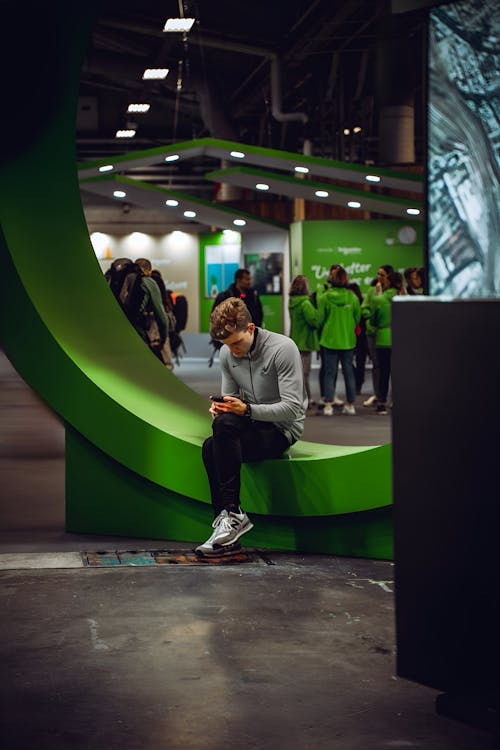 Man Sitting on Wall with Cellphone