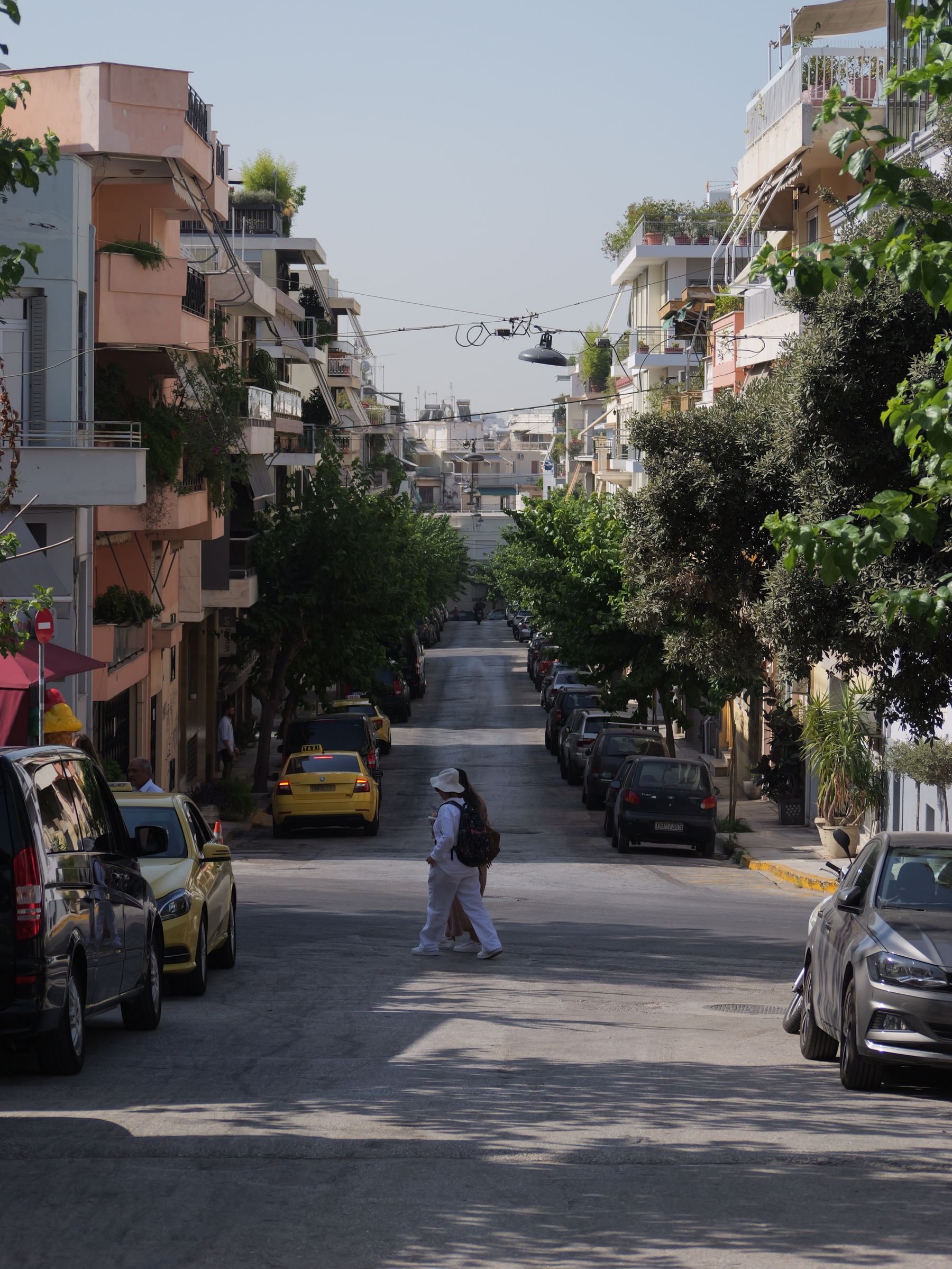 Πεζός σε δρόμο της Αθήνας με σταθμευμένα αυτοκίνητα