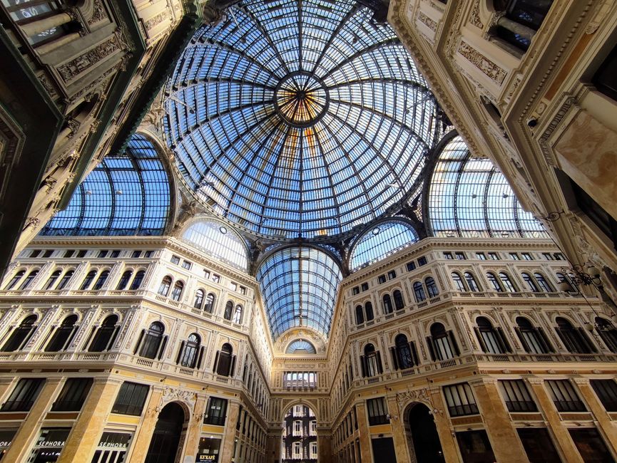 Stunning view of Galleria Umberto I's intricate glass dome and architecture in Naples, Italy.