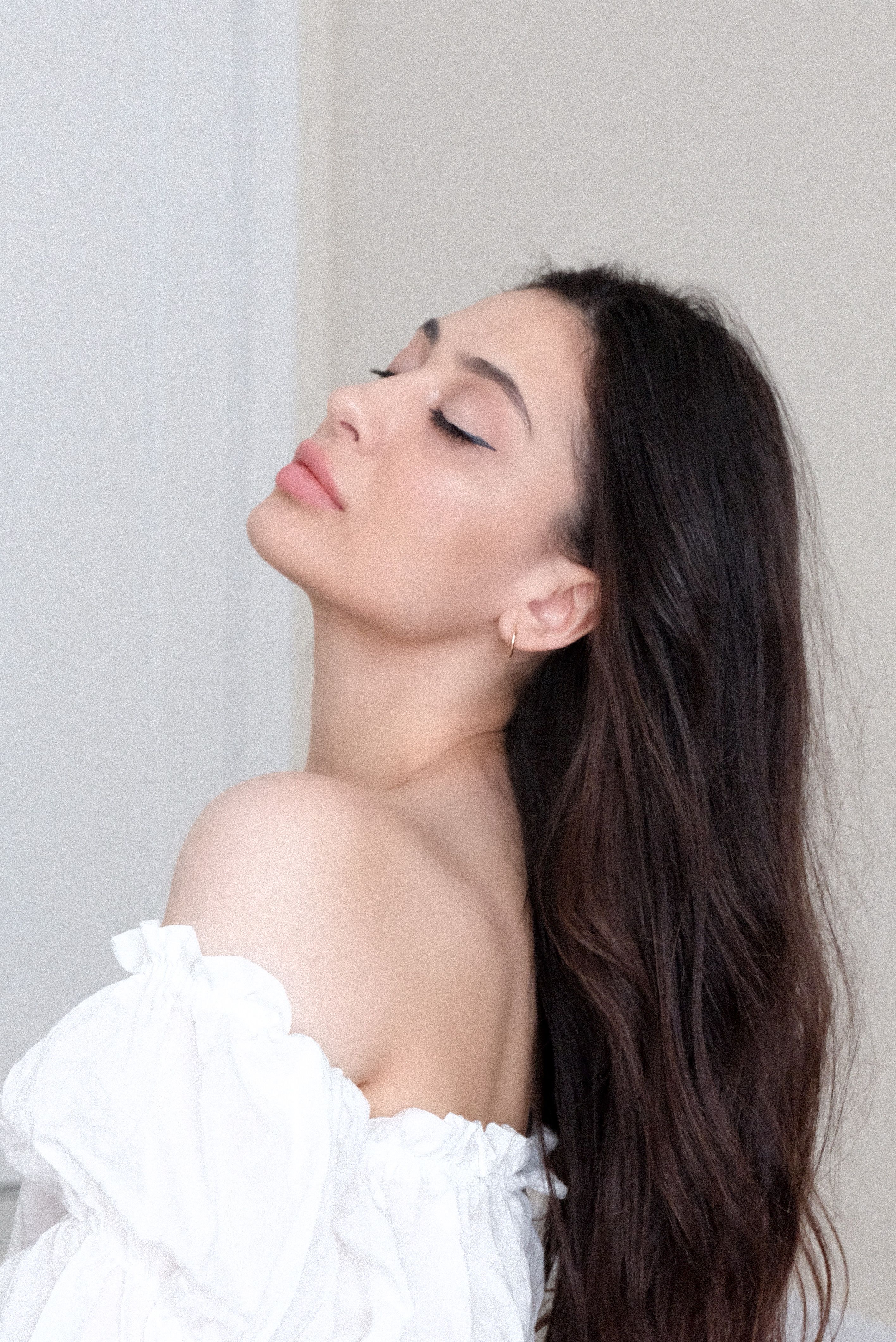 Captivating portrait of a woman with long hair in a soft, elegant pose. Perfect for lifestyle or fashion contexts.