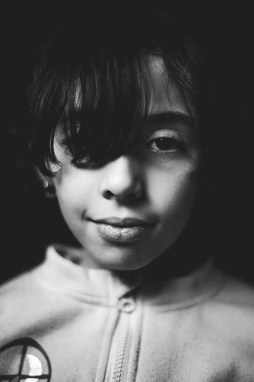 Free Captivating black and white portrait of a young girl with short hair and a serene expression. Stock Photo