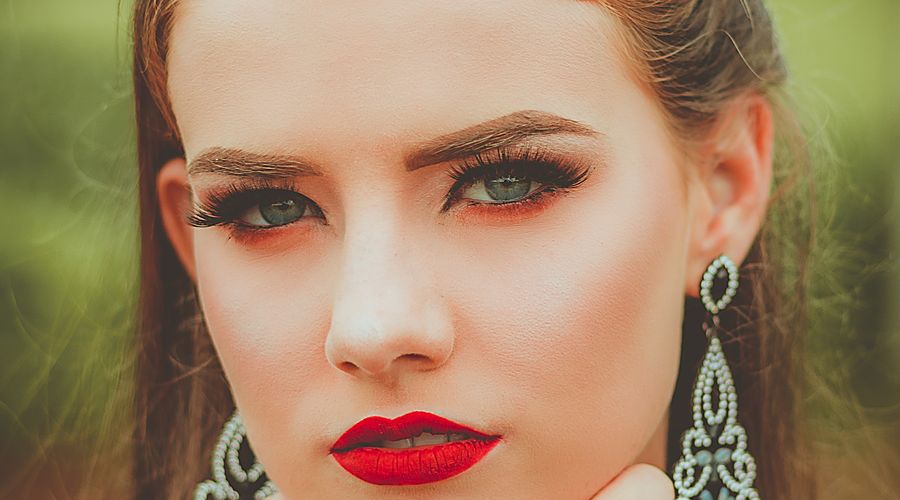 Femme portant des boucles d'oreilles argentées adaptées à la forme de son visage