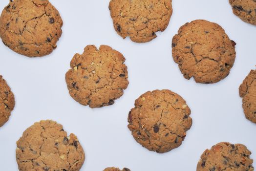 Flat lay of fresh chocolate chip cookies on a white background, ready to enjoy.