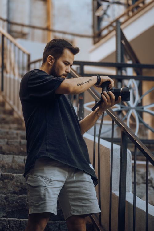 Free Photographer using a digital camera on an urban staircase outdoors. Stock Photo