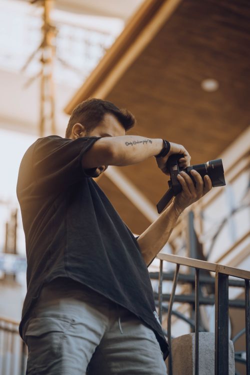 Free Photographer taking a shot from a low angle in an urban setting, highlighting the modern architecture. Stock Photo
