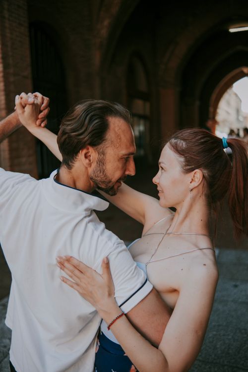 Free A couple shares an intimate dance in a sunlit archway, embracing love and connection. Stock Photo