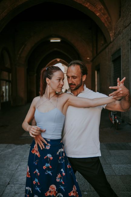 A couple gracefully dances under an arched ceiling, showcasing elegance and intimacy.