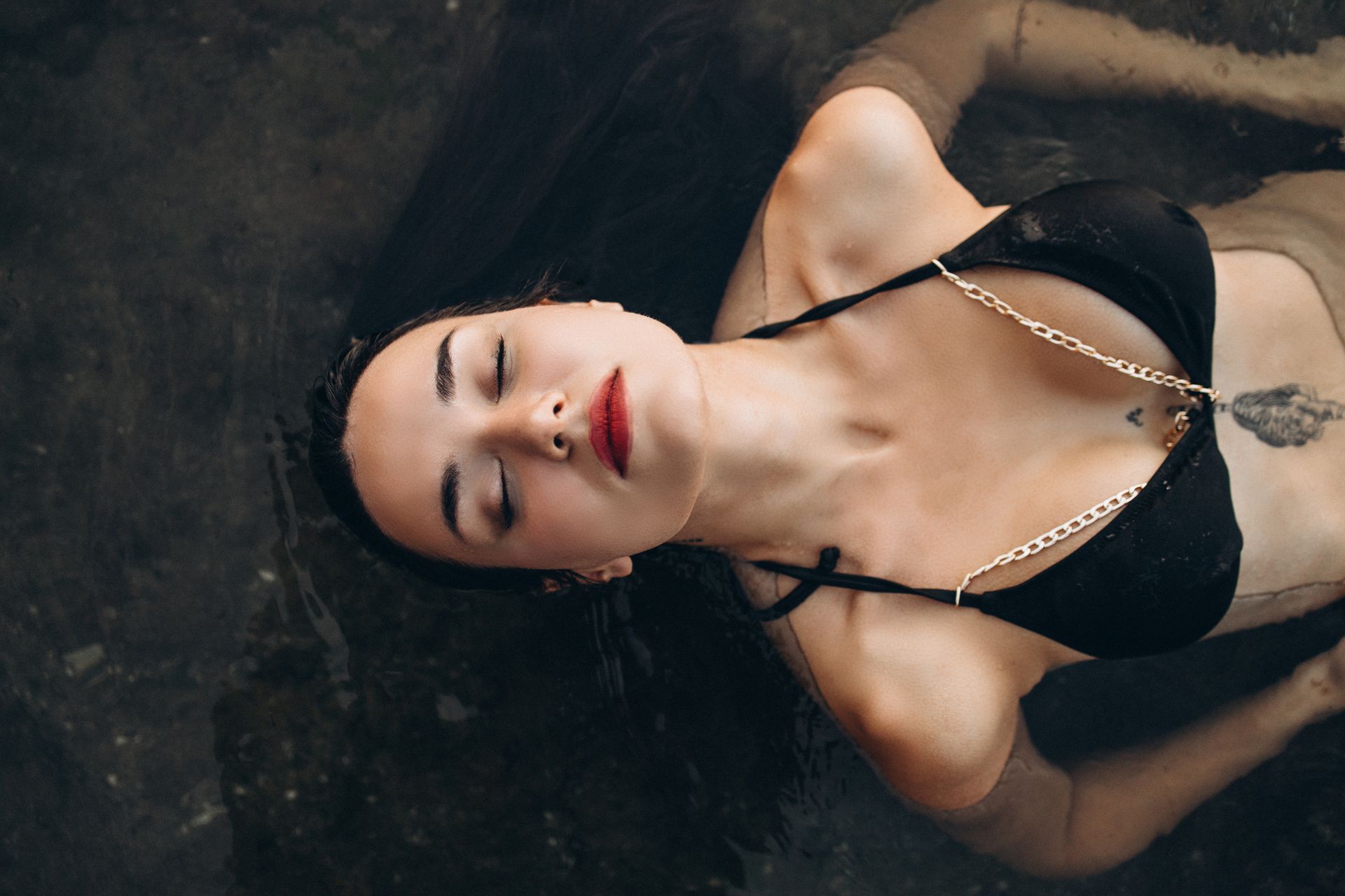 A woman laying down in the water with her head in the water