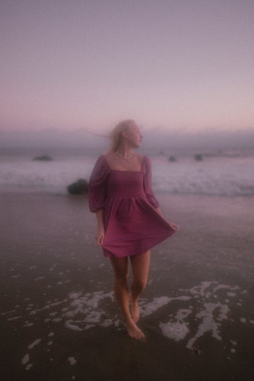 Young Woman in Pink Dress Posing on Beach