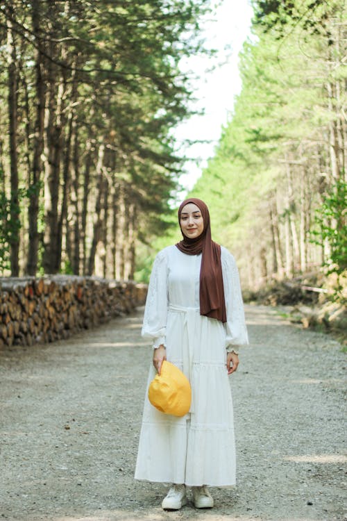 Woman in Hijab Standing on Dirt Road in Forest