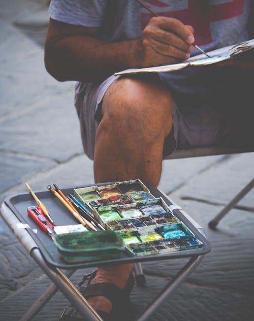 Free Tray with a Paint Palette and Brushes of a Street Painter Stock Photo