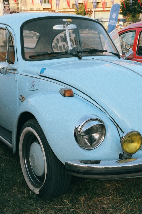 Free Light blue vintage Volkswagen Beetle parked on city street, showcasing retro style and vibrant urban scene. Stock Photo