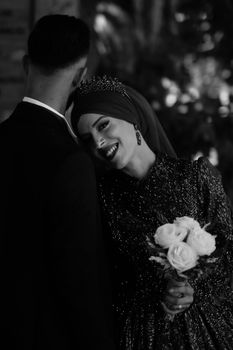 A joyful couple embracing in an elegant setting, captured in monochrome.