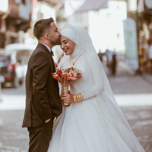 Free Smiling newlyweds embrace in a joyous street wedding moment, capturing romance and tradition. Stock Photo