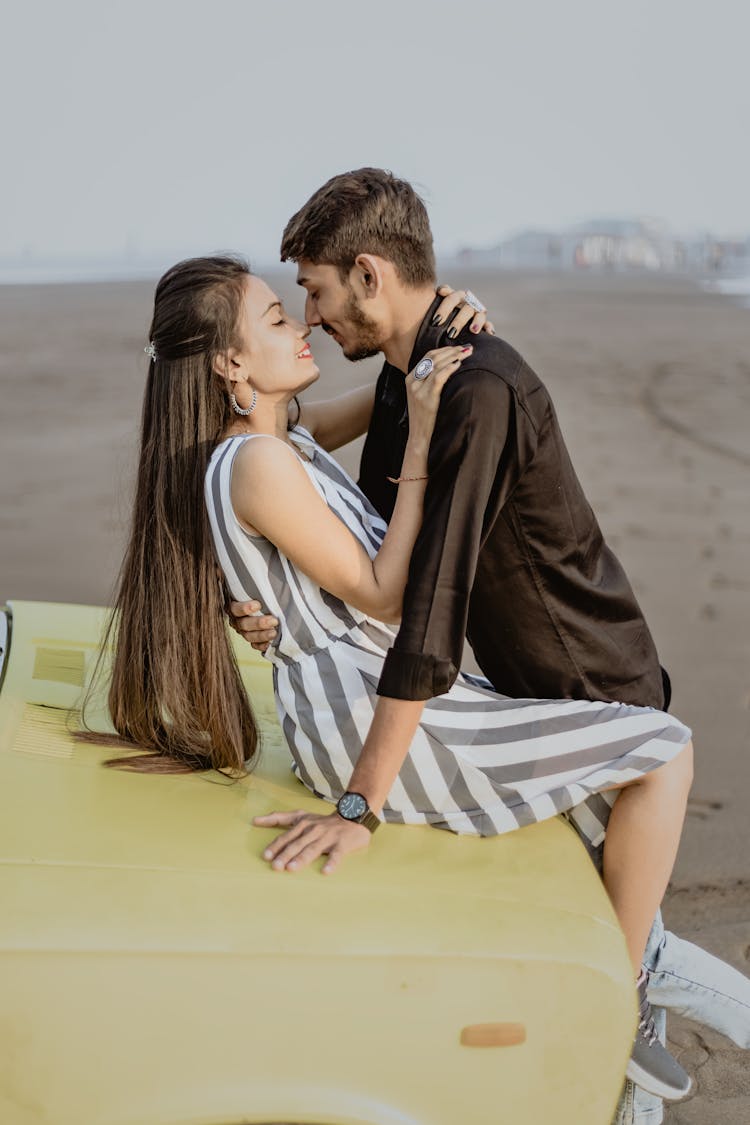 Young Couple Embracing On A Car Hood