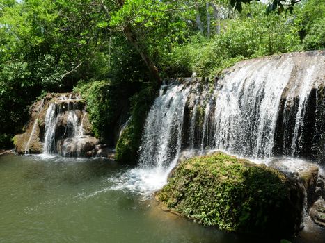 Beautiful waterfall amidst green forest in Bonito, Brazil. Tranquil nature scene with flowing water.