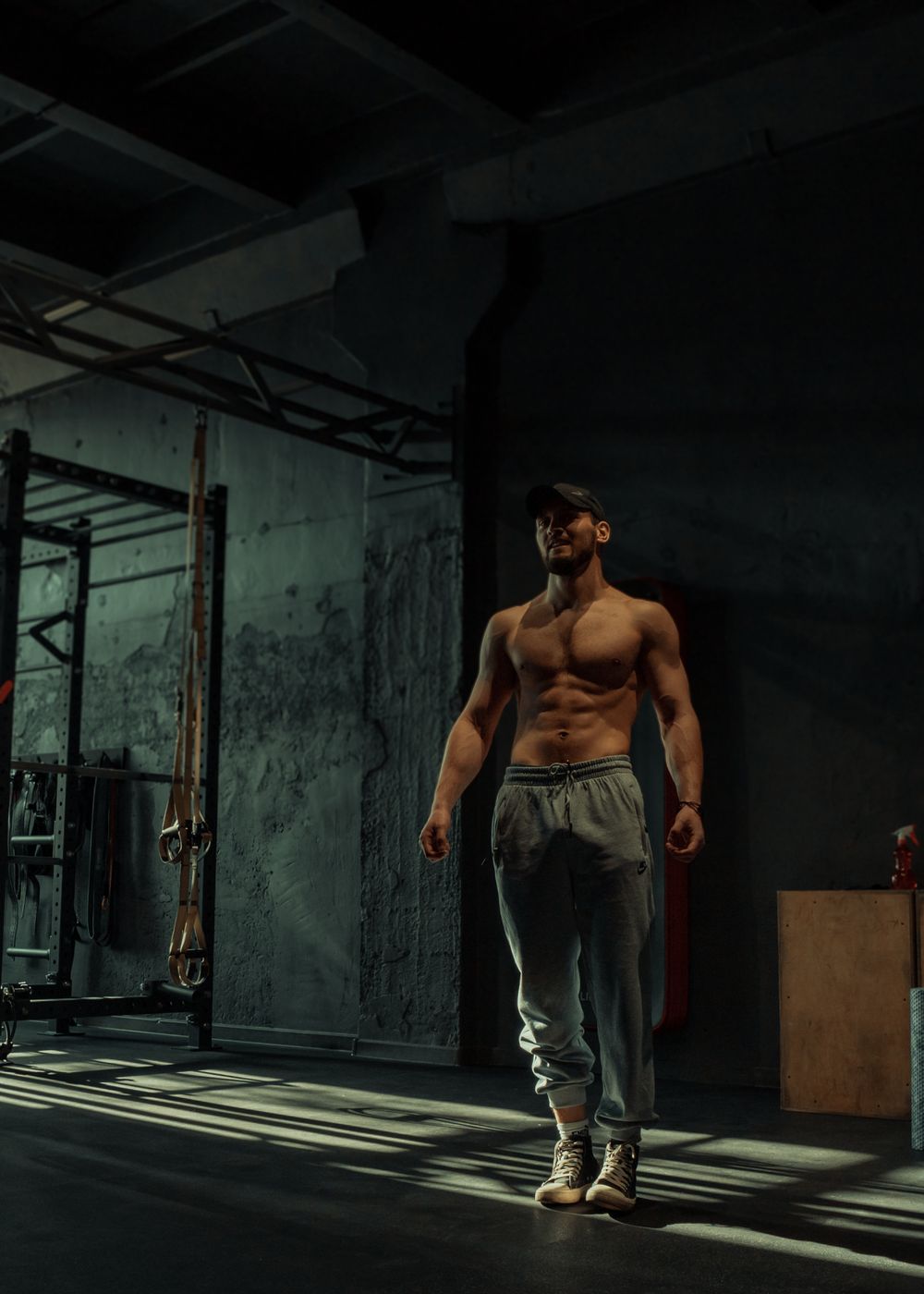 Male athlete standing confidently in a dark training environment
