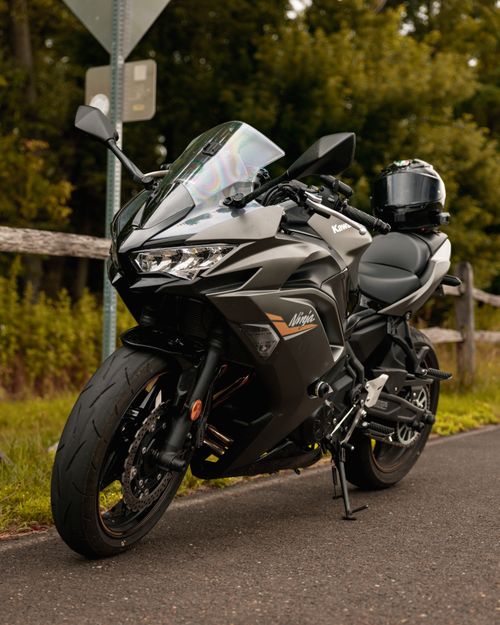 Free Sleek black Kawasaki Ninja motorcycle parked by a scenic roadside. Stock Photo