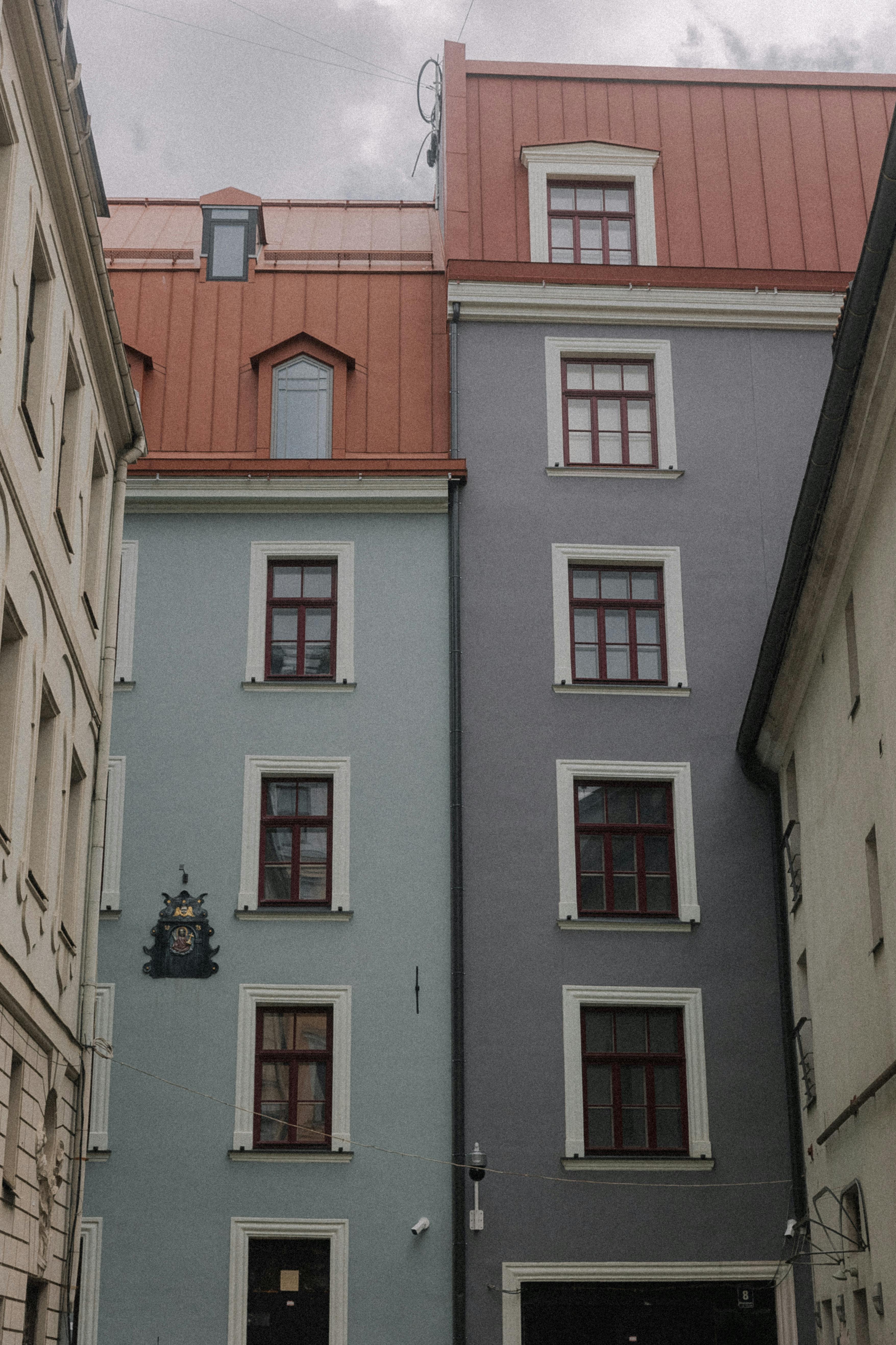 Vertical view of colorful urban buildings with distinctive red roofs and ornate windows.